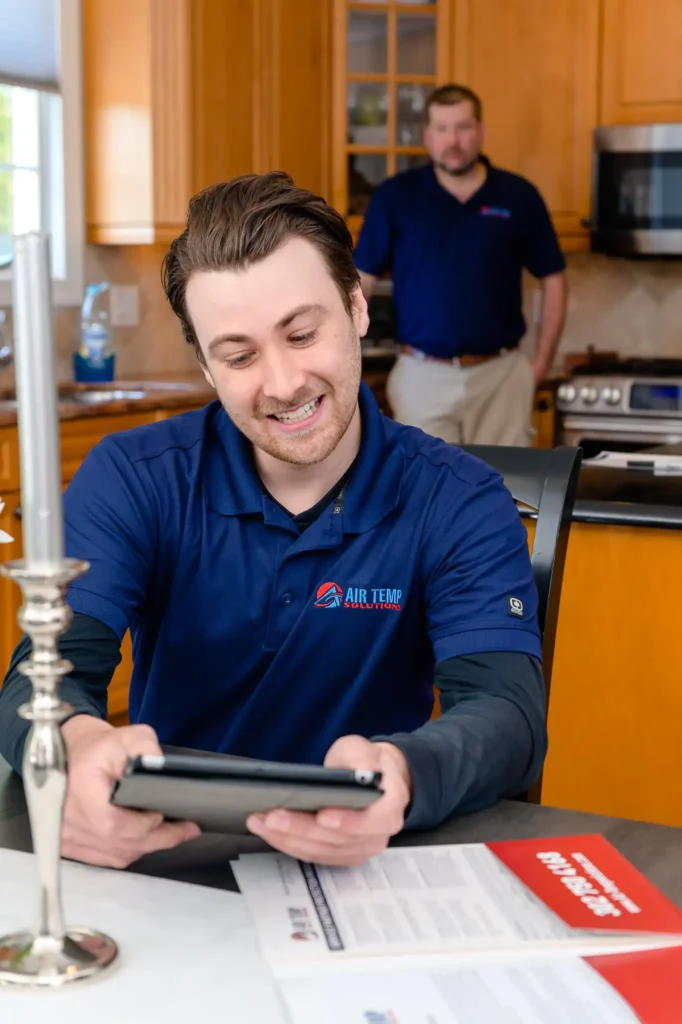 An HVAC tech sitting at a dining room table in a residential home