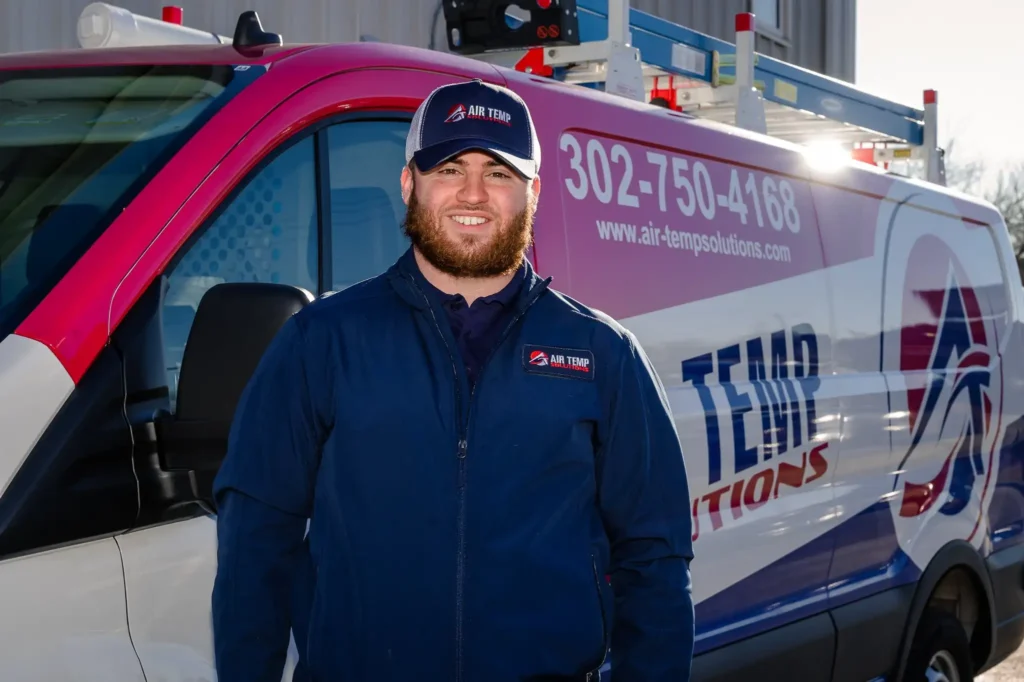 HVAC Tech smiling in front of an Air Temp Truck