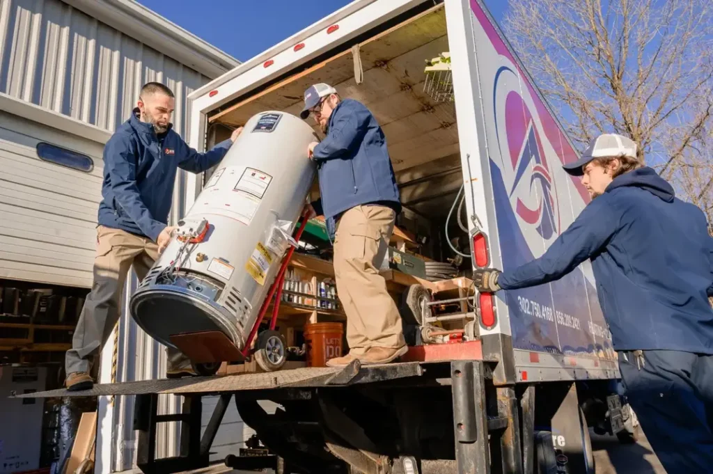 Techs bringing a water heater out of an Air Temp Truck
