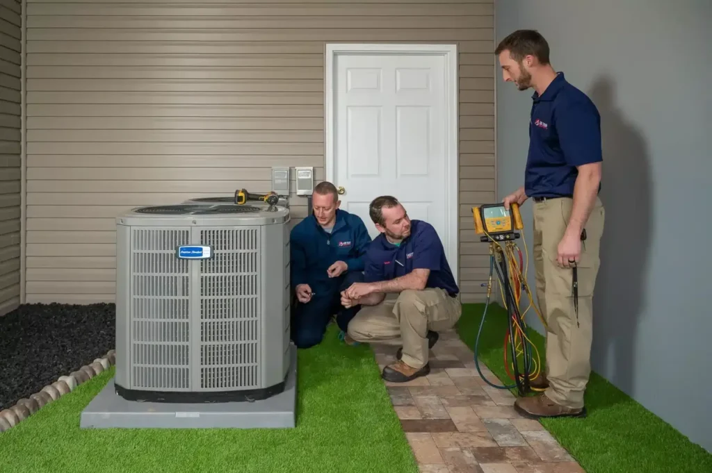 3 techs standing outside a house installing a new heat pump