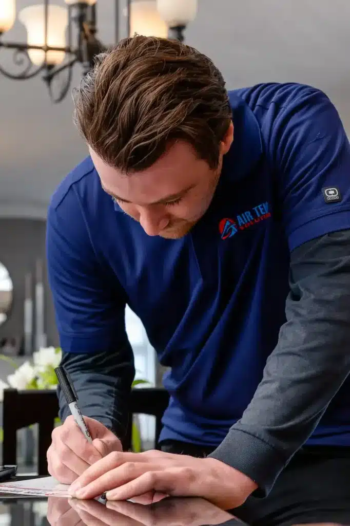 HVAC tech writing at a dining room table