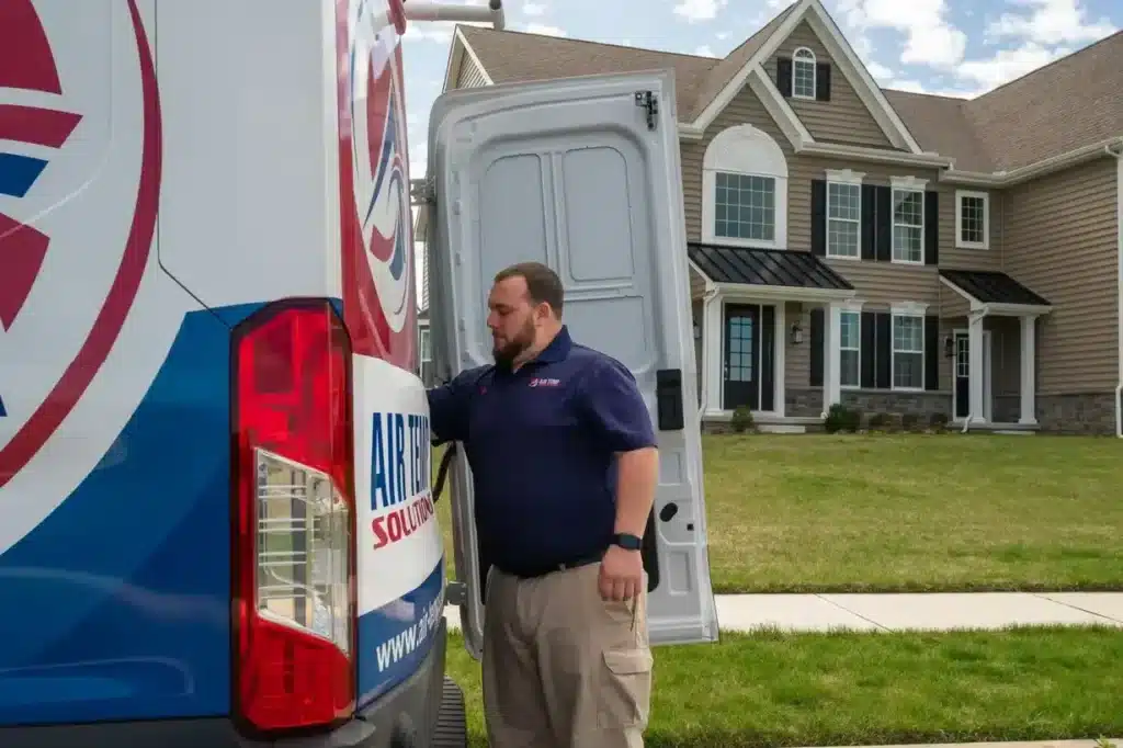 HVAC Tech reaching into an Air Temp van for supplies