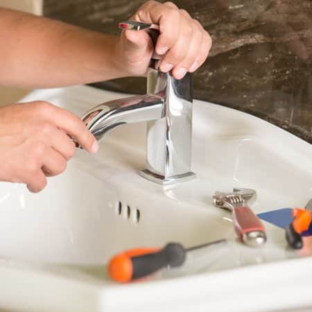 Tech working on a sink faucet