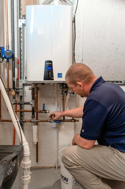 Tech working om a tankless water heater